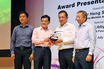 SUMBAN DERMA: Encik Heng (dua dari kiri) menyampaikan cenderahati kepada Encik Peter Lim sewaktu majlis penyampaian Biasiswa Yayasan Olimpik Singapura (SOF)-Peter Lim di Politeknik Temasek semalam. Turut hadir ialah Encik Ng Ser Miang (kanan) dan Speaker Parlimen Encik Tan Chuan-Jin (kiri). - Foto BH oleh GIN TAY