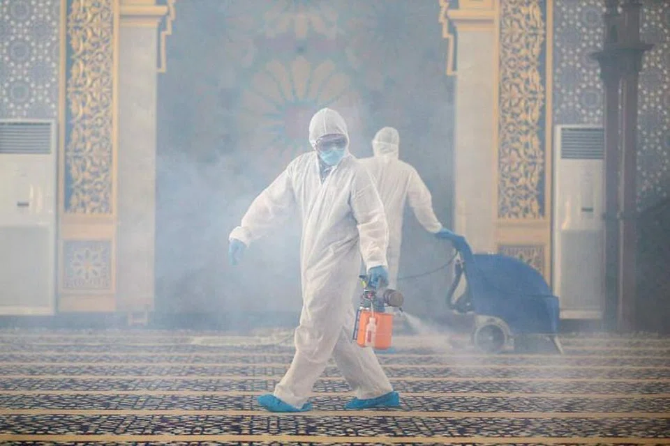 Dalam satu gambar pada 17 Mac, para pekerja memakai sut perlindungan untuk menyah jangkit sebuah masjid di Brunei. 