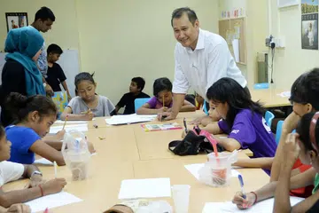 BANTU TINGKATKAN PENDIDIKAN AWAL KANAK-KANAK: Encik Faizal (tengah) bersama pelajar-pelajar daripada keluarga berpendapatan rendah, telah menjalankan program perintis KidSTART di daerah Taman Jurong dan Boon Lay bersama ECDA. - Foto fail