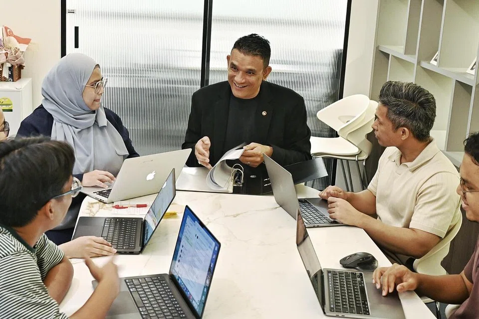 Presiden Dewan Perniagaan dan Perusahaan Melayu Singapura (DPPMS), Encik Abdul Malik Hassan (tengah), bersama kakitangan dewan perniagaan itu di pejabat mereka di pusat beli-belah Grantral Mall di MacPherson.