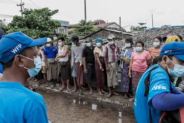 BERATUR DAPATKAN BERAS: Orang ramai di Yangon beratur untuk dapatkan bekalan beras yang diagihkan pertubuhan Program Makanan Dunia (WFP) sebagai sebahagian usaha membantu penduduk miskin yang kekurangan bekalan makanan. - Foto AFP
