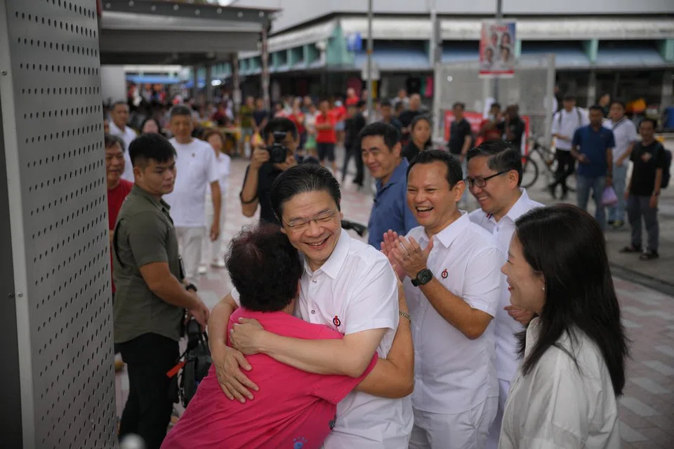 Perdana Menteri, Encik Lawrence Wong (didakap seorang penduduk) bersama anggota lain pasukan GRC Marsiling-Yew Tee (dari kanan) Cik Hany Soh, Encik Alex Yam dan Encik Zaqy Mohamad di Pasar Marsiling pada 4 Mei.