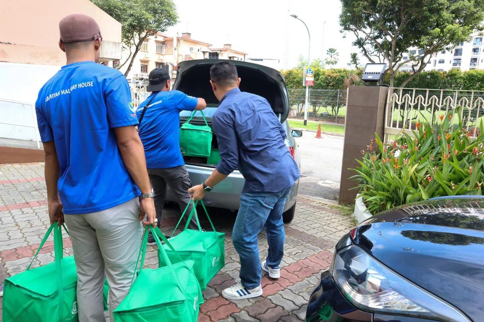 AGIH DAGING KORBAN: Pihak Jamiyah Singapura mengagih daging korban yang diletakkan dalam bekas dan beg kepada sohibul korban melalui perkhidmatan pandu lalu di Pusat Jamiyah pada Sabtu.