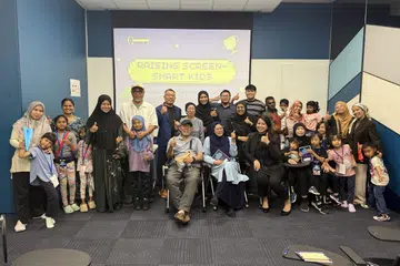 Dr N Erlyani Abd Hamid (duduk, tiga dari kiri) dan dua rakan karyawannya,  Encik Hafiz Noorahman (berdiri, tengah, berbaju kotak-kotak) dan Cik Noretta Jacob (berdiri, tengah, bertudung hitam) telah mempelopori program celik digital bagi ibu bapa, Screen Smart Carnival, sempena acara Raikan Ilmu, anjuran Yayasan Mendaki.