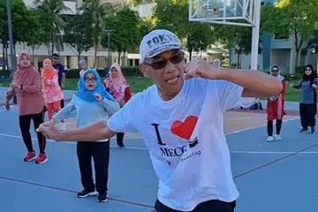 SENAM BERSAMA: Encik Mohamed Khairi Supani (bertopi) mengadakan kelas tarian cergas beramai-ramai di ruang yang dikongsi bersama di serata Singapura. Senaman ini diharap dapat membantu masyarakat Singapura kekal sihat.