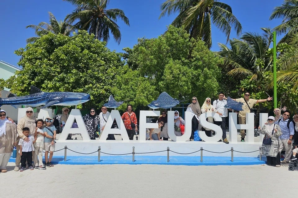 Wajah-wajah ceria seluruh anggota keluarga penulis bergambar kenangan di hadapan mercu tanda tulisan besar ikonik Pulau Maafushi yang menjadi pintu gerbang utama percutian bajet mereka di Maldives.