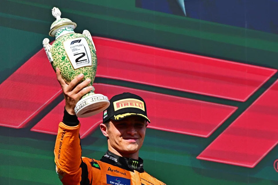 Pemandu McLaren, Lando Norris, meraikan kejayaan dengan trofi di atas podium selepas menduduki tempat kedua di Grand Prix Hungary.