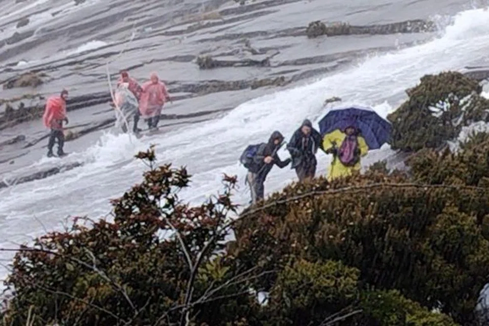 SITUASI BERBAHAYA: Foto tangkap skrin dari video memaparkan usaha  jurupandu dan malim gunung  untuk membawa turun kumpulan pendaki dari puncak Gunung Kinabalu, Sabah pada 4 Disember .