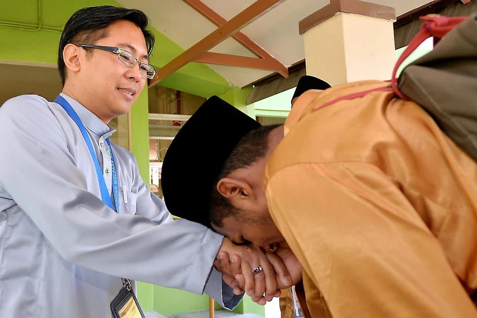 MEMINTA KEMAAFAN: Seorang penghuni Rumah Kebajikan Muhammadiyah (RKM) bersalaman dengan Penolong Superintenden RKM, Encik Nazri Saad, sebelum pulang beraya bersama keluarganya. - Foto KHALID BABA