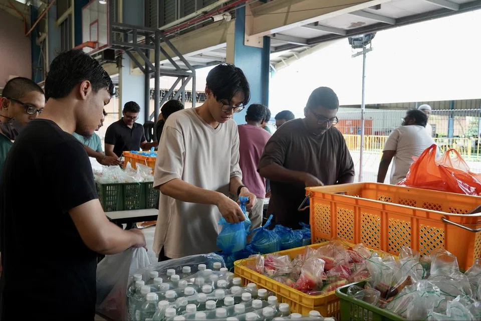 Badan belia, IMYouth, menggembleng tenaga menyiapkan hidangan berbuka puasa seperti minuman, bubur dan buah-buahan untuk disajikan bagi pekerja migran di pusat riadah Penjuru.
