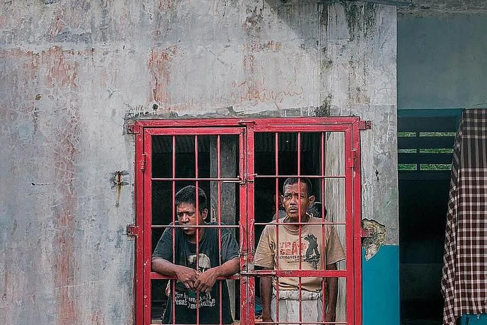 MENGHARAP DI BALIK JERIJI: Dua pesakit mental ini mengharapkan bantuan selepas terkurung di dalam ruang khusus bagi penghuni lelaki di Pondok Pesantren Ar-Ridwan. - Foto THE CHAIN FILMS