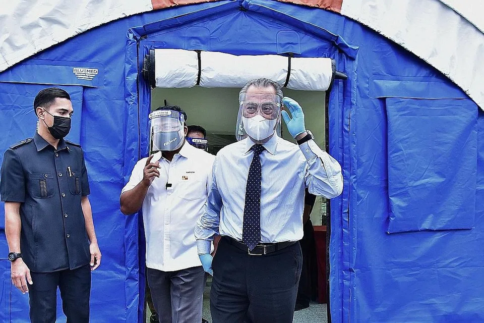 TINJAU KEMUDAHAN: Tan Sri Muhyiddin Yassin (kanan) meninjau kemudahan kuarantin bagi pesakit Covid-19 di Taman Ekspo Pertanian Malaysia (MAEPS), Serdang pada Januari lalu. - Foto AFP