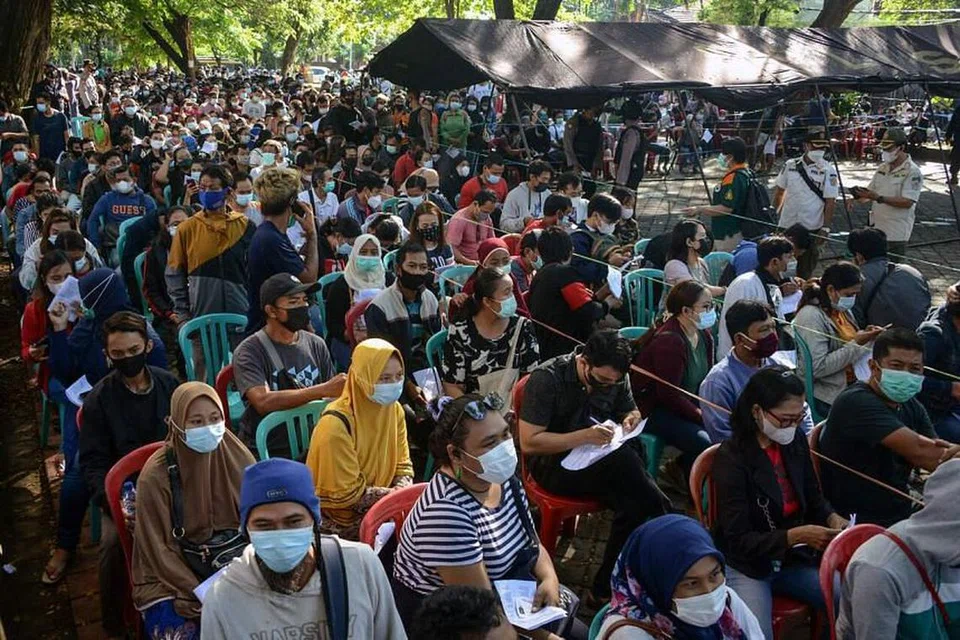 Orang ramai beratur untuk mendaftar mendapatkan vaksin AstraZeneca Covid-19 di Bali, Indonesia. - FOTO AFP