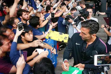 JADI TARIKAN: Penjaga gawang Gianluigi Buffon (kanan) bergambar dan memberi autograf kepada peminat yang menantinya di Hotel JW Marriot Singapore South Beach sedang pasukan Paris Saint Germain (PSG) tiba untuk perlawanan Piala Juara-Juara Antarabangsa (ICC). Pemain berusia 40 tahun ini menjadi tarikan selepas peminat kecewa apabila bintang muda seperti Neymar dan Kylian Mbappe tidak hadir kerana terlibat dalam Piala Dunia. - Foto BM oleh GAVIN FOO