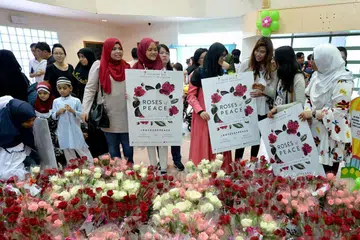 BALAS KEBENCIAN DENGAN KEAMANAN: Sukarelawan gerakan memupuk keamanan dan keharmonian antara kaum dan agama, Roses of Peace (ROP), mengadakan pengagihan bunga mawar sebagai tanda keamanan. - Foto fail