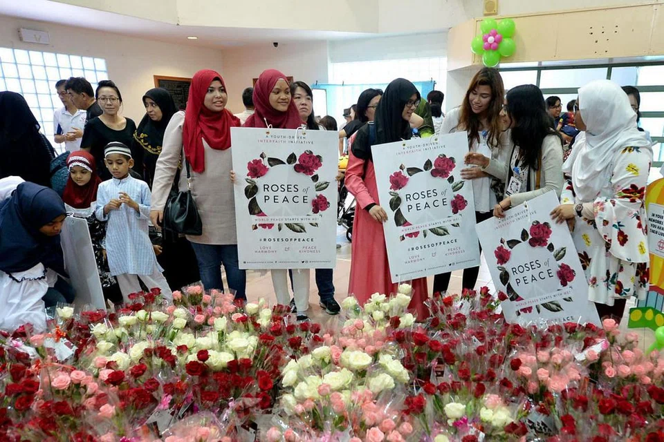 BALAS KEBENCIAN DENGAN KEAMANAN: Sukarelawan gerakan memupuk keamanan dan keharmonian antara kaum dan agama, Roses of Peace (ROP), mengadakan pengagihan bunga mawar sebagai tanda keamanan. - Foto fail