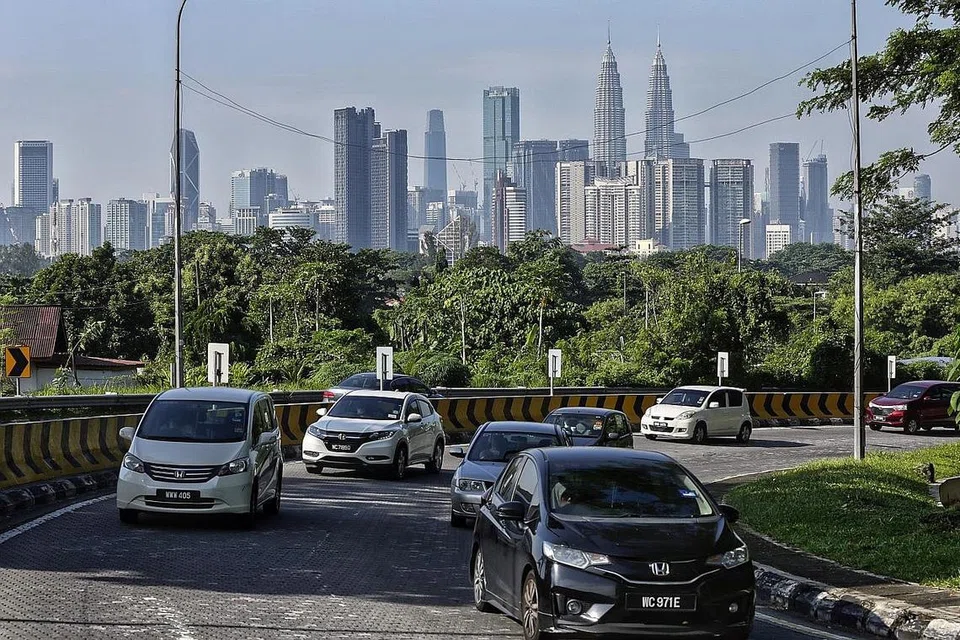 DIJANGKA SESAK: Lalu lintas bergerak berlatar belakang latar langit Kuala Lumpur kelmarin. Trafik dijangka meningkat tinggi, terutama dari malam esok hingga hujung minggu, apabila ramai rakyat Malaysia balik ke kampung atau bercuti selepas sekatan perjalanan rentas sempadan ditarik balaik semalam. - Foto EPA-EFE