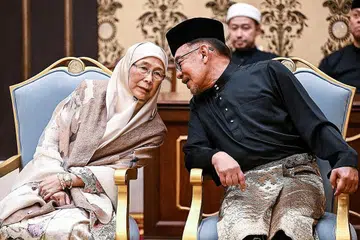 TUNGGAK SOKONGAN: Datuk Seri Anwar berkongsi detik bersejarah diangkat sebagai Perdana Menteri Malaysia ke-10 dengan isterinya, Dr Wan Azizah Wan Ismail, yang keluar dari balik tabir untuk meneruskan reformasi sepanjang beliau dipenjara. - Foto REUTERS 