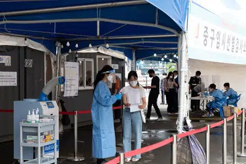 PENJAGAAN KESIHATAN: Seorang petugas kesihatan (kiri) memeriksa seorang warga yang hadir bagi ujian pemeriksaan Covid-19 di sebuah klinik sementara di Seoul, Korea Selatan, pada 28 Jun lalu. Pihak berkuasa negara itu menyatakan kes jangkitan harian ini yang melonjak sekarang melibatkan varian Delta koronavirus. - Foto EPA-EFE