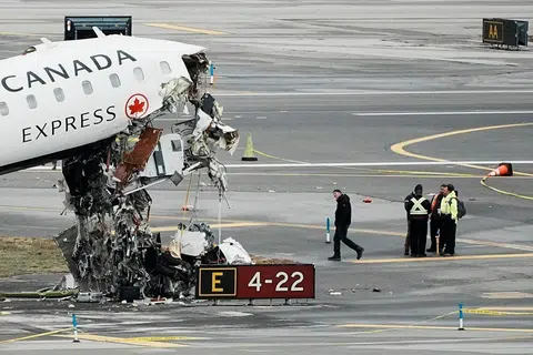 Para pegawai daripada Lembaga Keselamatan Pengangkutan Kebangsaan menjalankan pemeriksaan ke atas bangkai pesawat Air Canada di Lapangan Terbang LaGuardia di Queens, New Yorik, Amerika Syarikat, pada 23 Mac 2026. 