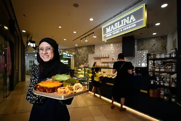 TERAPKAN PEMBAHARUAN: Sebagai anak muda lulusan SIM, Cik Adibah cuba menerapkan pembaharuan dalam perniagaan tradisi seperti menawarkan penjualan dalam talian (www.delimaslina.com) serta memasarkan produknya di media sosial. - Foto BM oleh LIM YAOHUI