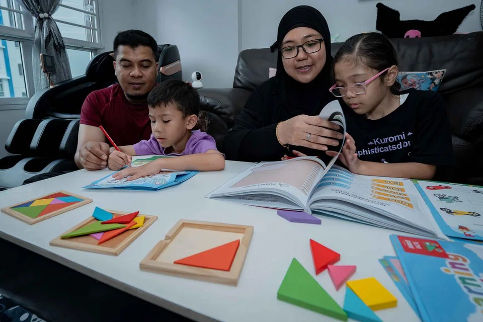 Cik Mardiana Idrus (dua dari kanan) bersama suaminya, Encik Mohammad Jufri Ramli, 40 tahun, sama-sama melakukan aktiviti eKelasMateMatika (eKMM) bersama anak mereka.