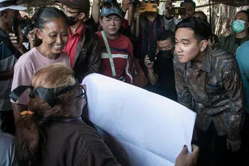 LALUAN TERBUKA: Encik Gibran Rakabuming Raka (kanan), anak Presiden Indonesia, Encik Joko Widodo, bersama seorang aktivis di Surakarta, Jawa Tengah, pada Isnin. Beliau kini boleh bertanding dalam Pilihan Raya Presiden selepas Mahkamah Perlembagaan memutuskan calon presiden atau naib presiden boleh berusia kurang 40 tahun. 
