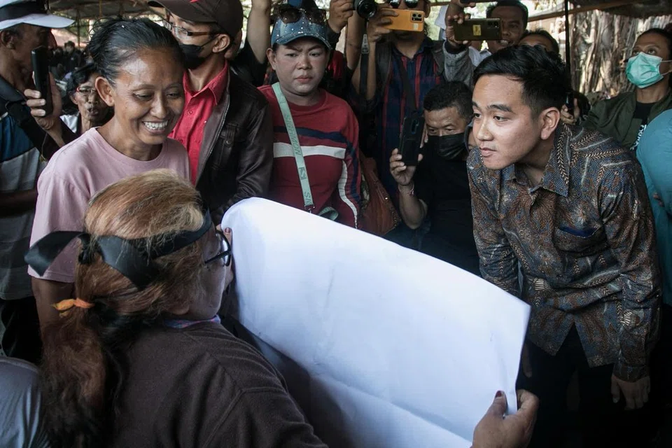 LALUAN TERBUKA: Encik Gibran Rakabuming Raka (kanan), anak Presiden Indonesia, Encik Joko Widodo, bersama seorang aktivis di Surakarta, Jawa Tengah, pada Isnin. Beliau kini boleh bertanding dalam Pilihan Raya Presiden selepas Mahkamah Perlembagaan memutuskan calon presiden atau naib presiden boleh berusia kurang 40 tahun. 
