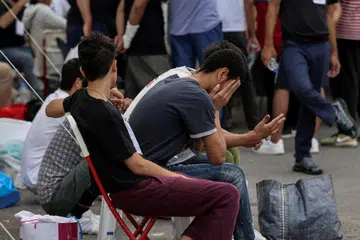 TERSELAMAT: Pendatang yang terselamat dari kapal karam di kawasan perairan terdalam di Mediterranean menunggu bas untuk dipindahkan ke Athens dari pelabuhan Kalamata, Greece pada 16 Jun.