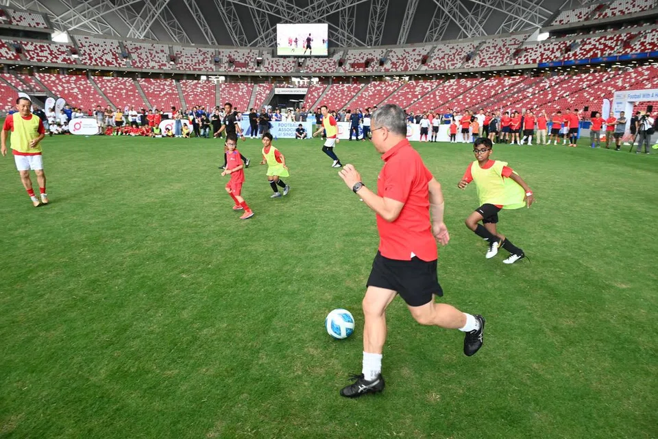 Menteri Kebudayaan, Masyarakat dan Belia, Encik Edwin Tong (dua dari kanan), bermain bola sepak bersama kanak-kanak di acara menyambut ulang tahun ke-20 program Bola Sepak Masyarakat PAssion (PACF).