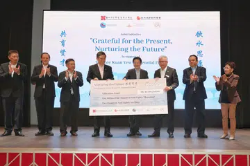 PENYAMPAIAN CEK: Wakil daripada lima pertubuhan dewan perniagaan dan persatuan etnik setempat, termasuk (dari kanan) Presiden EA, Cik Sanda Theseira; Pengerusi SICCI, Encik Neil Parekh; Presiden SFCCA, Encik Thomas Chua; Presiden SCCCI, Encik Kho Choon Keng (tiga dari kiri) dan Presiden SMCCI, Encik Abu Bakar Mohd Nor (paling kiri),  menyampaikan cek bernilai $10,180,286 dalam satu majlis yang disaksikan oleh Timbalan Perdana Menteri, Encik Lawrence Wong (empat dari kanan). Turut hadir ialah Menteri Pendidikan, Encik Chan Chun Sing (empat dari kiri) dan Menteri Tenaga Manusia merangkap Menteri Kedua Perdagangan dan Perusahaan, Dr Tan See Leng (dua dari kiri).