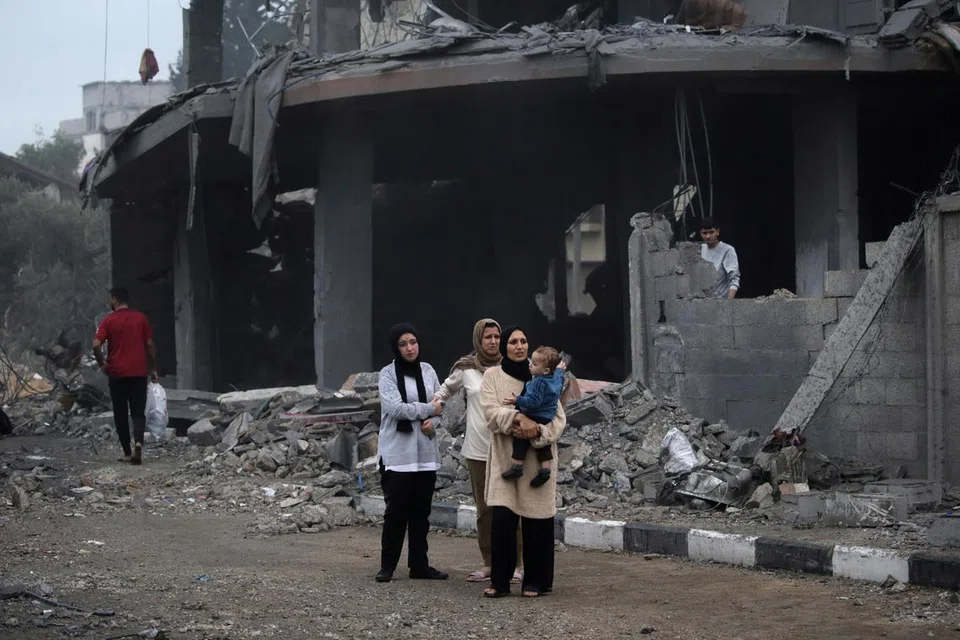 KE MANA LAGI?: Warga Palestin berjalan untuk mencari tempat perlindungan di  kawasan runtuhan bangunan akibat pengeboman tentera Israel di Deir Al Balah, selatan Gaza, pada 5 Disember.