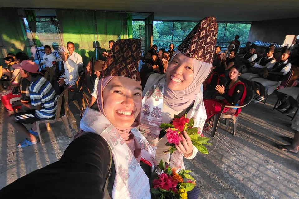 HARI PELANCONGAN SEDUNIA: Penulis (kiri) bersama rakannya, Cik Khairiyah Kang dengan buah tangan bunga, topi dan juga selempang yang mereka terima daripada penduduk di Golaghat.