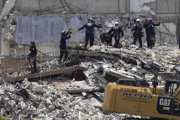 CARI MANGSA: Usaha mencari dan menyelamat diteruskan bagi mengesan mangsa tragedi runtuhan sebahagian blok pangsapuri 12 tingkat di Florida. - Foto AFP