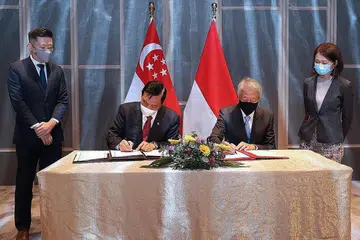 TINGKAT KERJASAMA: Encik Teo Chee Hean (kanan) dan Encik Luhut Pandjaitan menandatangani MOU yang akan melihat kerjasama lebih mendalam antara Singapura dengan Indonesia berhubung kemampanan dan perubahan iklim. - Foto MCI