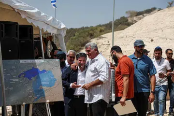 Menteri Kewangan Israel, Bezalel Smotrich (depan paling kiri) berinteraksi dengan seorang lelaki pada hari sidang akhbar mengenai peluasan penempatan bagi projek E1 yang lama dibekukan, yang akan memisahkan Baitulmakdis Timur daripada Tebing Barat yang diduduki, berhampiran penempatan haram Israel Maale Adumim di Tebing Barat yang diduduki Israel, pada 14 Ogos 2025.