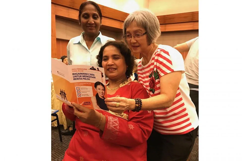 TINGKATKAN PEMAHAMAN: (Duduk) Cik Emilia Ramalan Muslia Mohamed, 57 tahun bersama dua lagi temannya, Cik Guan Gek Choon, 67 tahun dan Cik Rada Raj, 62 tahun, kesemuanya daripada Khidmat Masyarakat Tanglin telah diberikan brosur tentang bagaimana cara-cara untuk mengenal pasti berita palsu, sebagai sebahagian daripada Hari Pembelajaran Perkhidmatan di ITE Kolej Timur. - Foto BH oleh SHAHIDA SARHID