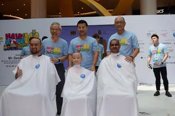 KORBAN RAMBUT: (Depan, dari kiri) Encik Horis Hosri, Wilson Wu Wen Hong dan Encik Sheam Kannan masing-masing dicukur oleh (belakang, dari kiri) penaung CCF, Profesor Madya Ho Peng Kee; Menteri Pembangunan Sosial dan Keluarga, Encik Desmond Lee; dan Pengerusi CCF, Encik Ho Cheng Huat. 