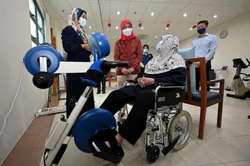 LAKUKAN KUNJUNGAN: Presiden Halimah Yacob (dua dari kiri) beramah mesra dengan Cik Salmah Maon, 80 tahun, sewaktu lawatannya ke SATA CommHealth semalam. Bersamanya Cik Siti Zubaidah Yusoff (kiri), penolong pengarah di SATA CommHealth, dan Encik Stanley Sia, pengerusi SATA CommHealth (kanan). - Foto BH oleh LIM YAOHUI