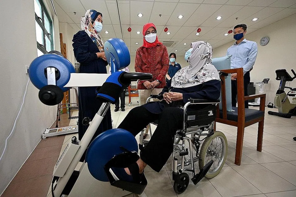 LAKUKAN KUNJUNGAN: Presiden Halimah Yacob (dua dari kiri) beramah mesra dengan Cik Salmah Maon, 80 tahun, sewaktu lawatannya ke SATA CommHealth semalam. Bersamanya Cik Siti Zubaidah Yusoff (kiri), penolong pengarah di SATA CommHealth, dan Encik Stanley Sia, pengerusi SATA CommHealth (kanan). - Foto BH oleh LIM YAOHUI