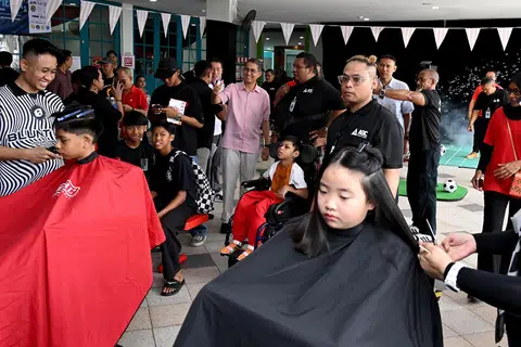 Khidmat gunting rambut disediakan oleh kedai gunting rambut Atatcutz bagi pengunjung di ‘Fund the Fight Fiesta SG60’. 