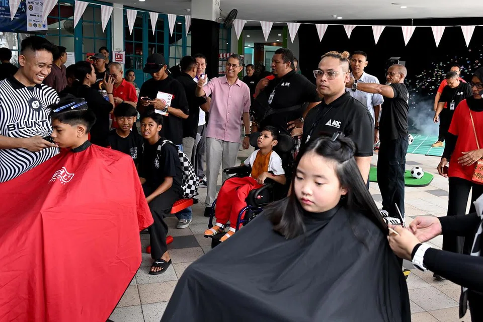 Khidmat gunting rambut disediakan oleh kedai gunting rambut Atatcutz bagi pengunjung di ‘Fund the Fight Fiesta SG60’. 