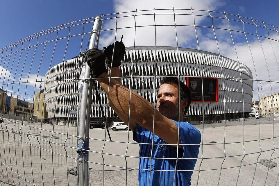 LANGKAH BERJAGA-JAGA: Seorang pekerja memasang pagar di perkarangan Stadium San Mames agar memisahkan penyokong Atletico Bilbao daripada mendekati stadium itu. - Foto EPA-EFE