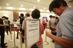 Warga Singaporeans beratur untuk menukar Baucar GST kepada wang tunai. 