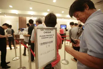 Warga Singaporeans beratur untuk menukar Baucar GST kepada wang tunai. 