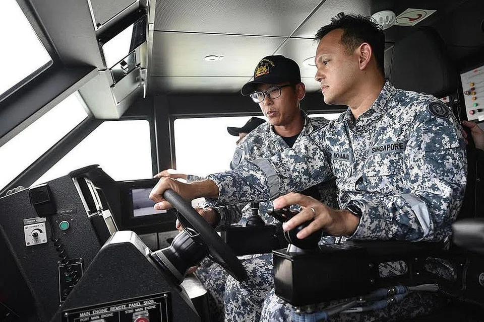 TINGKAT KEUPAYAAN: Encik Zaqy (kanan) berinteraksi bersama anggota RSN, termasuk anggota Perkhidmatan Negara sepenuh masa daripada Skuadron Kapal Permukaan Tanpa Pemandu (USV). - Foto MINDEF