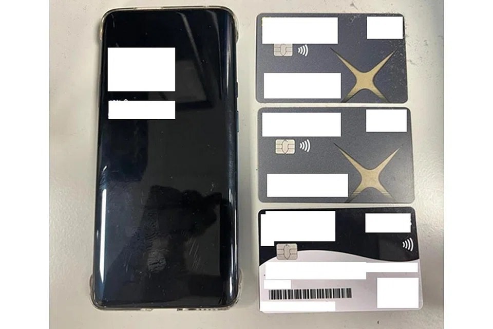 SIASATAN DIJALANKAN: Satu telefon bimbit dan tiga kad bank juga telah dirampas. - Foto-foto SINGAPORE POLICE FORCE