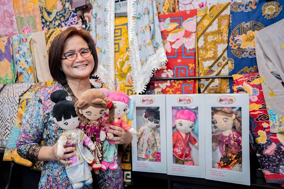 Cik Ratianah Tahir bersama tiga anak patung daripada inisiatif Orkids by Ratianah sebagai sebahagian usaha melestari warisan budaya kebaya. 