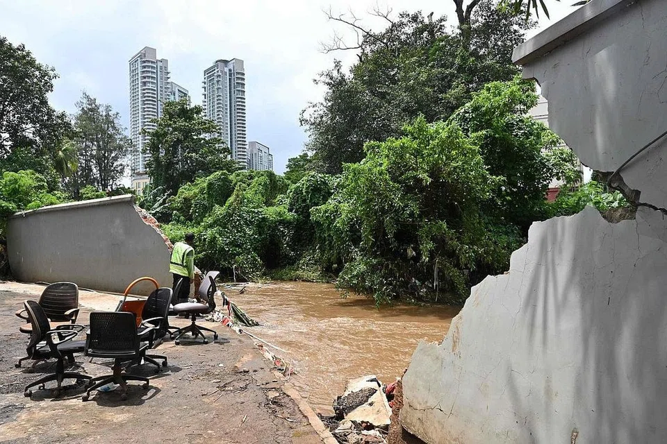BENTENG ROBOH: Air yang melimpah dari Sungai Krukut menyebabkan benteng di tepi sungai tersebut roboh, sekali gus mengakibatkan banjir di kawasan Kemang di Jakarta kelmarin. - Foto AFP