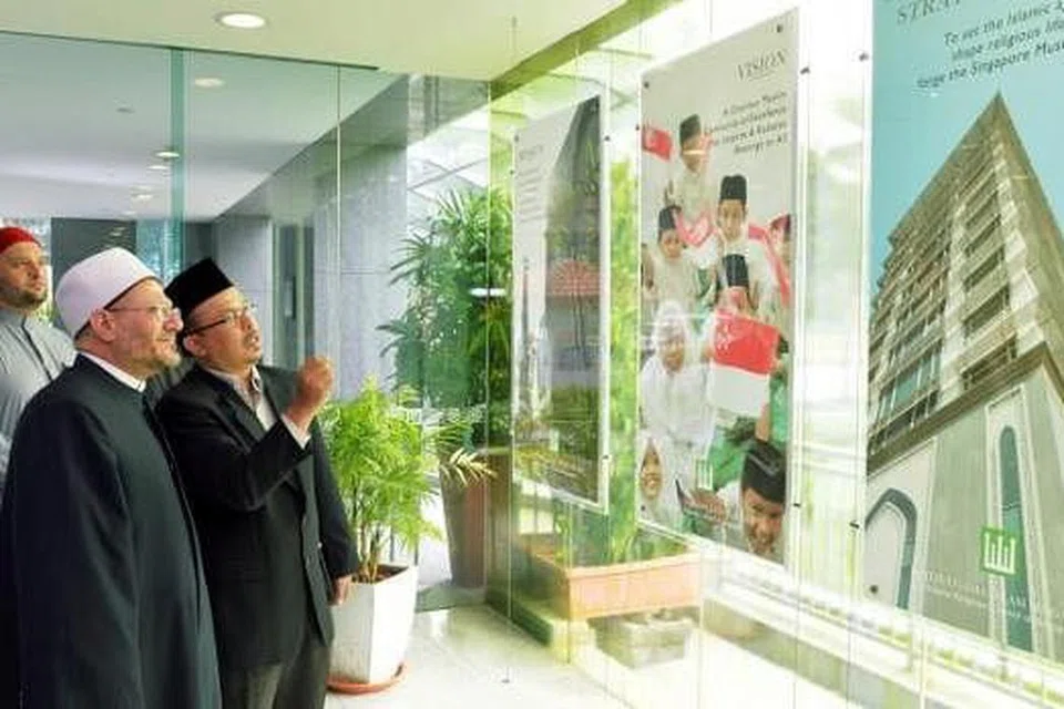 HAB ISLAM SINGAPURA: Ustaz Mohd Murat Mohd Aris menunjukkan pameran di bangunan Muis kepada Sheikh Dr Shawki dan Dr Ibrahim Negm, penasihat kanan Mufti Besar Mesir (belakang). - Foto KHALID BABA